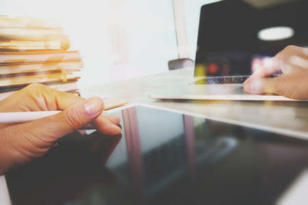 Website designer working digital tablet and computer laptop with smart phone and digital design diagram and stack of books on wooden desk as conceptの写真素材