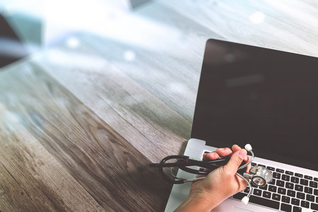 Medical technology concept. Doctor hand working with stethoscope and laptop computer with medical chart interface. View from top. Double exposure effects, Minimalismの写真素材