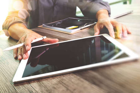 Businessman hand touching digital tablet.Photo finance manager working new Investment project office.Using new technology device.Graphic icons.Strategy business stock exchanges interface layer effect, Horizontalの写真素材