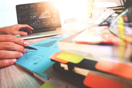 business documents on office table with smart phone and digital tablet and graph business with social network diagram and man working in the backgroundの写真素材