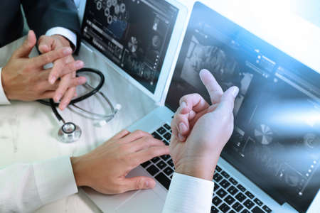 Medical technology network team meeting concept. Doctor hand working smart phone modern digital tablet laptop computer graphics chart interface, sun flare effect photoの写真素材
