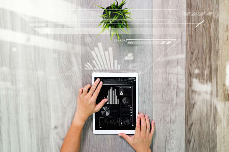 businessman hand working with digital tablet computer. Digital business strategy layer effect. On wood desk with plant. View from top. Double exposure effects, Minimalismの写真素材
