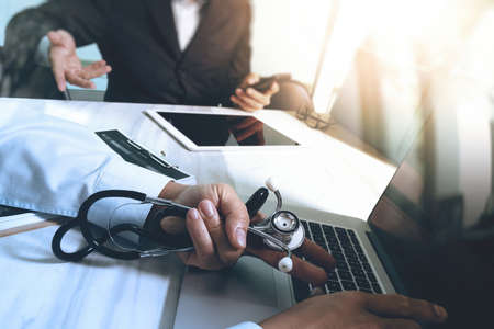 Medical technology network team meeting concept. Doctor hand working smart phone modern digital tablet laptop computer medical chart interface, double exposure effect photoの写真素材