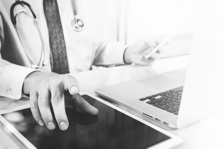 Medical technology concept. Doctor hand working with modern digital tablet and laptop computer with...