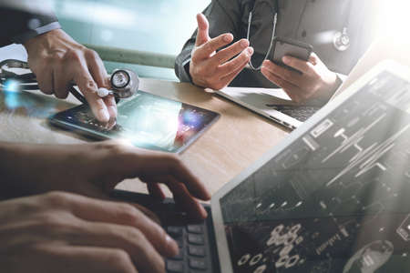 Medical technology network team meeting concept. Doctor hand working smart phone modern digital tablet laptop computer graphics chart interface, sun flare effect photoの写真素材