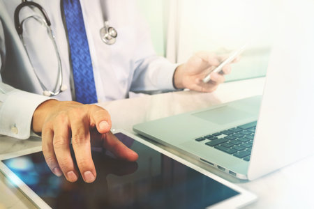 Medical technology concept. Doctor hand working with modern digital tablet and laptop computer with...