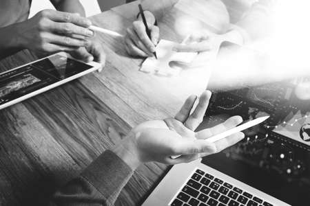 Team business meeting presentation. Hand businessman working new start up project in modern office.Laptop computer and digital table and smart phone on wood table, black whiteの写真素材