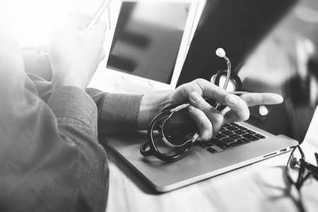 Medical technology concept. Doctor hand working with modern digital tablet and laptop computer with medical chart interface, black whiteの写真素材