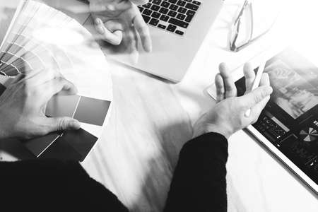 two colleague web designer discussing data and digital tablet and computer laptop with smart phone and design diagram on marble desk as concept, black whiteの写真素材
