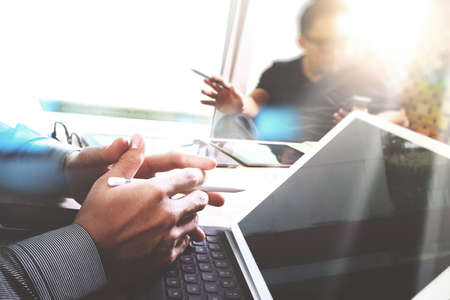 Business team meeting present. Photo professional investor working with new start up project. Digital tablet laptop computer design smart phone using, keyboard docking screen foreground,sun flareの写真素材