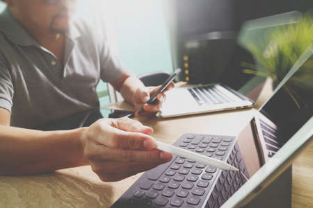 Outsource Developer working on marble Desk Working Laptop Computer Mobile Application Software and digital tablet dock smart keyboard,compact server,sun flare effectの写真素材