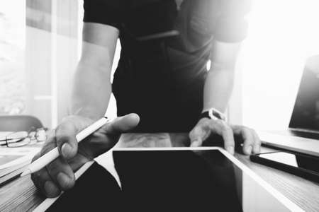 Website designer working digital tablet and computer laptop and digital design diagram on wooden desk as concept,black and whiteの写真素材