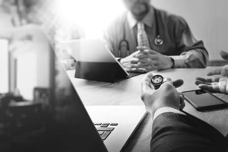 Medical technology network team meeting concept. Doctor hand working smart phone modern digital tablet laptop computer medical chart interface, black whiteの写真素材