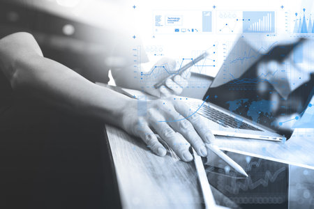 Designer hand working with laptop computer on wooden desk as responsive web design concept,black and...