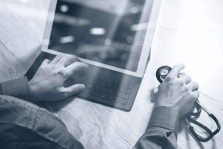 Medical technology concept. Doctor hand working with modern digital tablet dock screen computer with medical chart interface, Sun flare effect photo, black whiteの写真素材