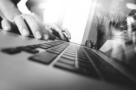 business man hand working on blank screen laptop computer on wooden desk as concept,black and whiteの写真素材