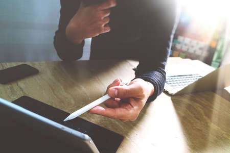 Website designer working digital tablet dock keyboard and computer laptop with smart phone and graphics design diagram on mable desk as conceptの写真素材