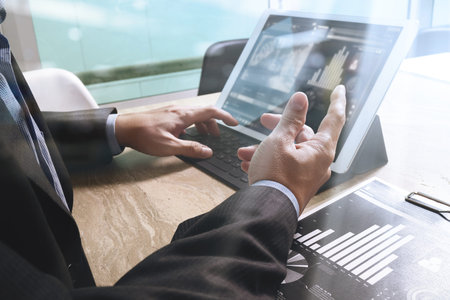Businessman hand working concept. Documents finance graphic chart. Digital tablet keyboard dock...