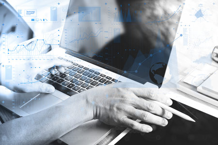 Designer hand working with laptop computer on wooden desk as responsive web design ,black and white