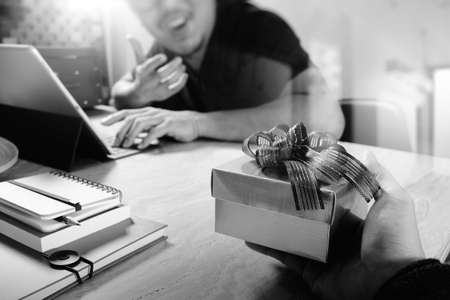 Gift Giving.business creative designer hand giving his colleague Christmas present in office,black whiteの写真素材