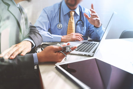 Medical technology network team meeting concept. Doctor hand working smart phone modern digital tablet laptop computer graphics chart interface, sun flare effect photoの写真素材