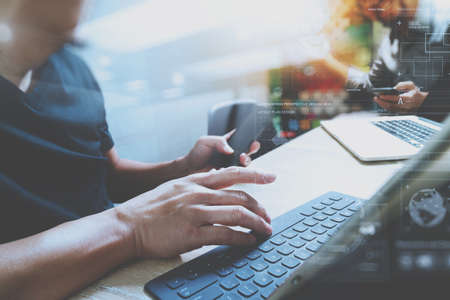 Coworking process, entrepreneur team working in creative office space. using digital tablet docking keybord and laptop with smartphone on marble desk,light beam effectの写真素材