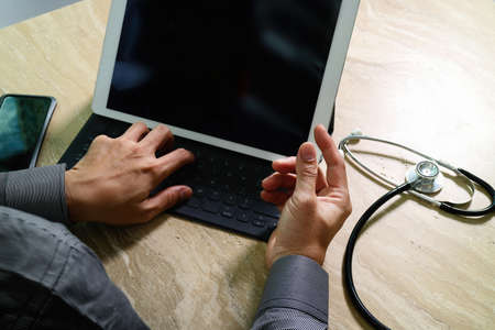 Medical technology concept. Doctor hand working with modern digital tablet dock screen computer with medical chart interface, Sun flare effect photoの写真素材