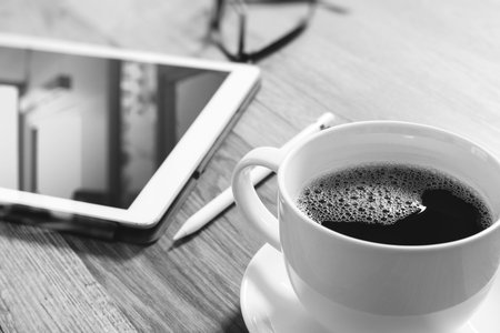 Coffee cup and Digital table dock smart keyboard,eyeglasses,stylus pen on wooden table,filter...