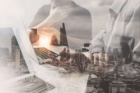 Double exposure of success businessman working in office with digital tablet laptop computer with London building and smart phone,filter effectの写真素材