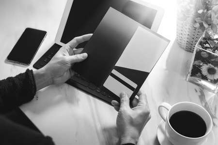 Businessperson Hands holding New Gift Card or Credit card,digital tablet computer dock keyboard,smart phone on marble desk,black whiteの写真素材