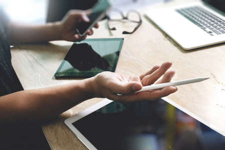 two colleague web designer discussing data and digital tablet and computer laptop with smart phone and design diagram on marble desk as conceptの写真素材