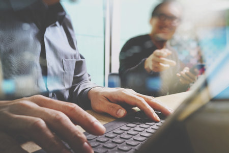 Team brainstorming task. Photo young creative managers crew working with new startup project  office.keyboard dock digital tablet on mable desk. sun flare effectの写真素材
