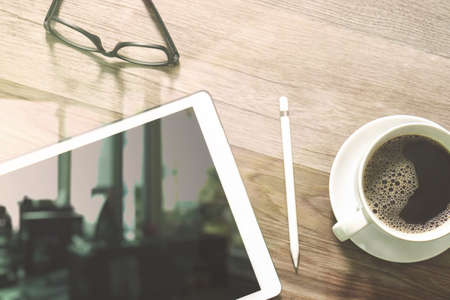 Coffee cup and Digital table dock smart keyboard,eyeglasses,stylus pen on wooden table,filter effectの写真素材