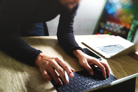 Website designer working digital tablet dock keyboard and computer laptop with smart phone and...