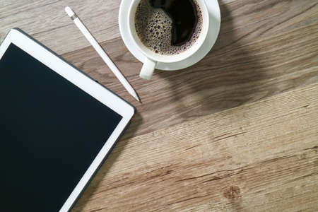 Coffee cup and Digital table dock smart keyboard,eyeglasses,stylus pen on wooden table,filter effectの写真素材