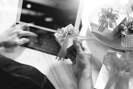 Gift giving Creative Hand typing and hand with gift. Gift delivery, surprise,tablet computer docking smart keyboard smart phone on mable desk,filter film effectの写真素材