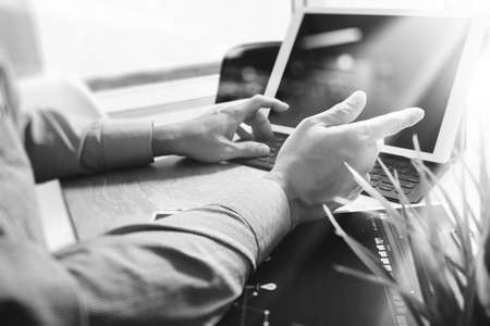 Businessman hand working concept. Documents finance graphic chart. Digital tablet keyboard dock screen computer design smart phone using. Sun flare effect, black whiteの写真素材