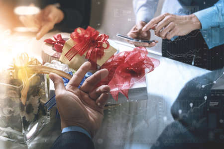 Gift giving Creative Hand using smart phone and co worker choosing gift. Gift delivery,office party,on marble meeting table,graphic icons,filter film effectの写真素材