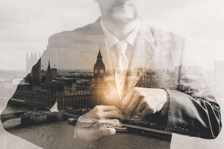 Double exposure of success businessman holding neck tie with London building,Bigben,front view,filter effectの写真素材