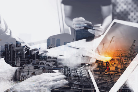 Double exposure of two colleague web designer discussing data and digital tablet docking keyboard and computer laptop with smart phone with London architecture,building の写真素材