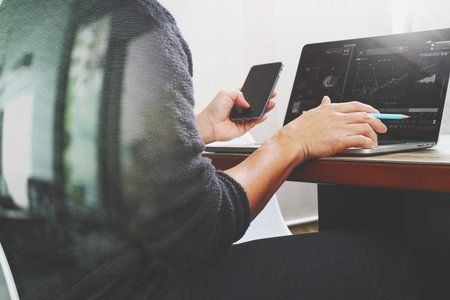Designer hand using mobile payments online shopping,omni channel,in modern office wooden desk,filter...