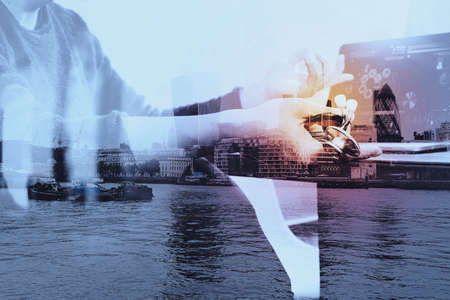Double exposure of smart medical doctor hand working with smart phone,digital tablet computer,stethoscope eyeglass,London architecture bulidingsの写真素材