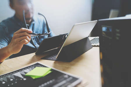 Website designer working digital tablet and computer laptop with digital tablet and digital design diagram on wooden desk and compact serverの写真素材