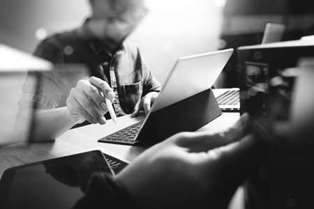 Website designer working digital tablet and computer laptop with digital tablet and digital design diagram on wooden desk and compact server