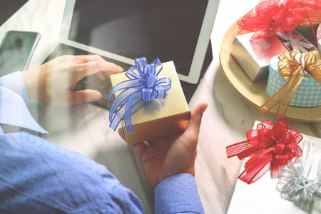 Gift giving Creative Hand choosing and hand with gift. Gift delivery, surprise,tablet computer docking smart keyboard smart phone on mable desk,vintage film effectの写真素材