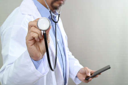 Medical technology concept. Doctor hand working with modern smart phone with medical chart interface,multi channel connection,white backgroundの写真素材