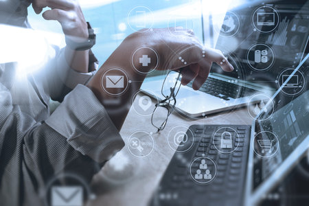 Designer hand using mobile payments online shopping,omni channel,in modern office wooden desk,icons graphic interface screen,eyeglass,filterの写真素材