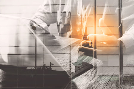 Double exposure of success businessman using smart phone,digital tablet docking smart keyboard  with London building,city,omnichannelの写真素材