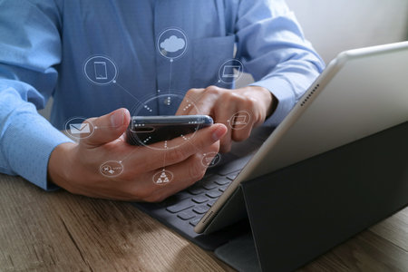 Businessman hand using mobile payments online shopping,omni channel,in modern office wooden...