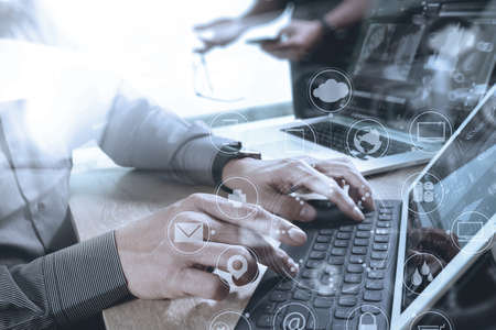 Co worker Designer hand using mobile payments online shopping,omni channel,in modern office wooden desk,icons graphic interface screen,eyeglass,filterの写真素材